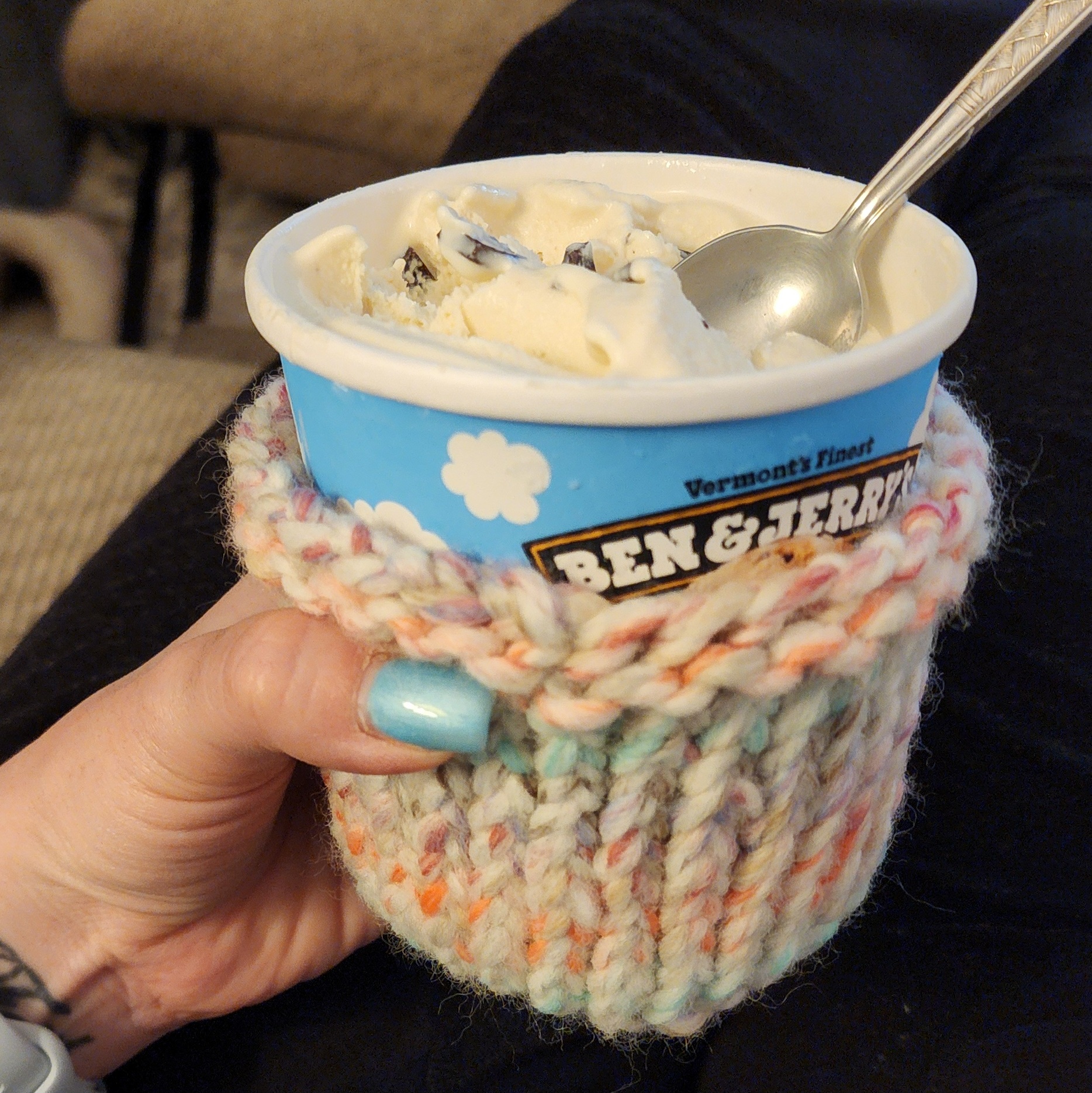 A handmade crochet ice cream cozy around a pint of Ben & Jerry's ice cream.